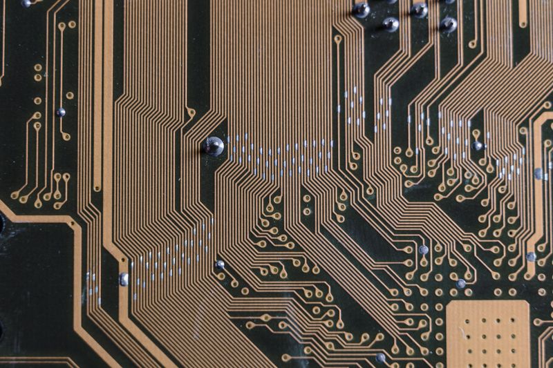 Placa de crossover con bobinas, capacitores y resistencias sobre mesa de taller